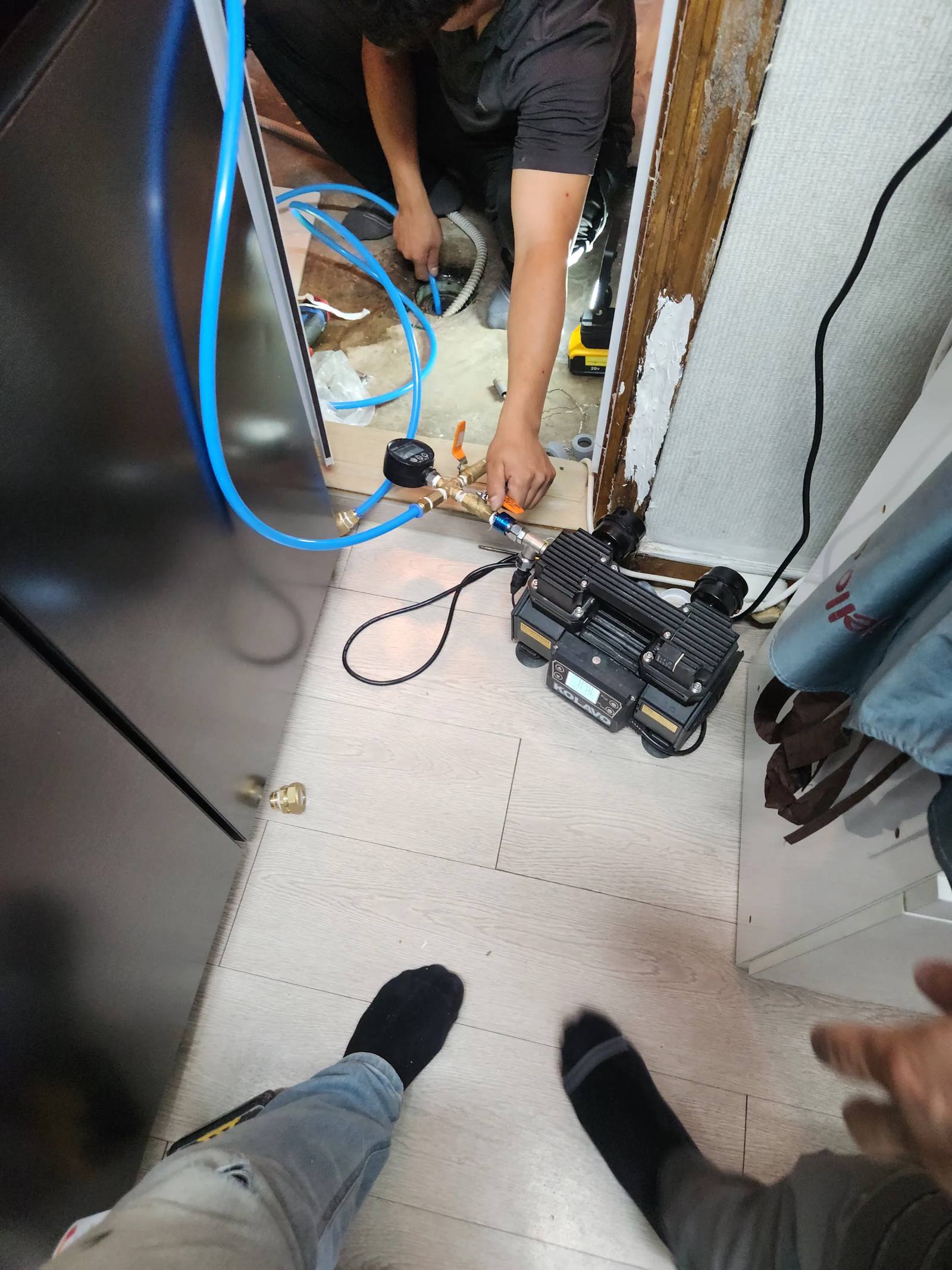 배관 연결부를 보수하고 압력 게이지로 테스트하는 모습